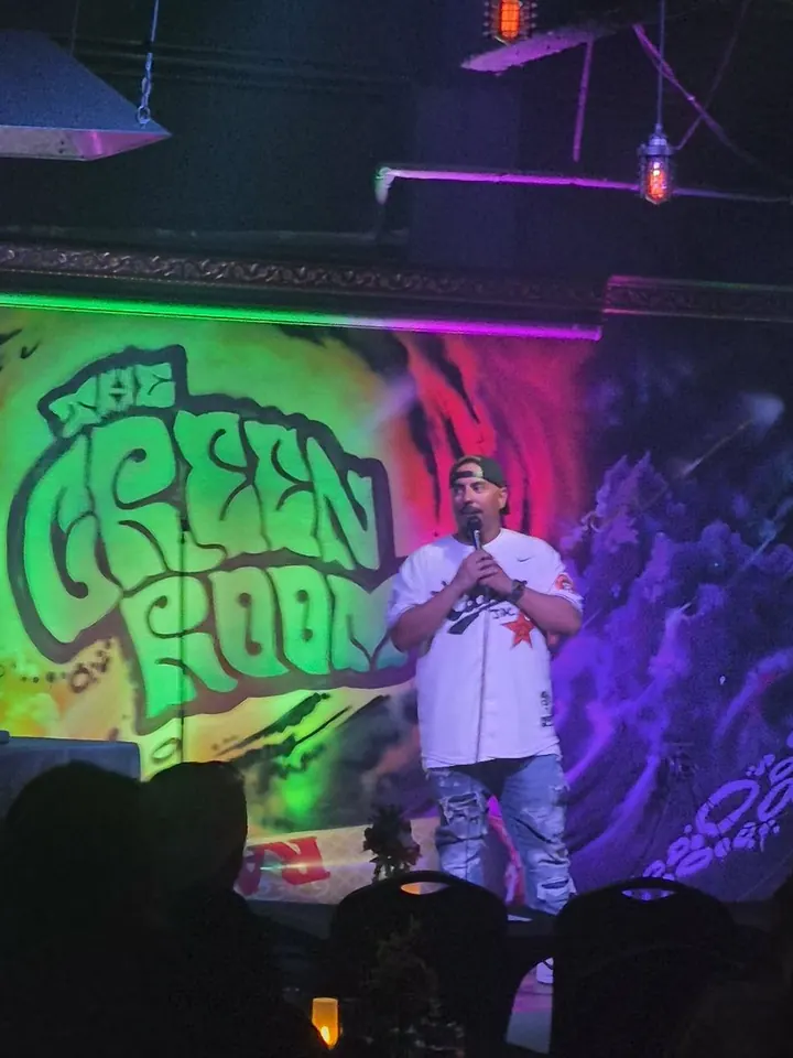 Chris on stage in front of the Green Room mural