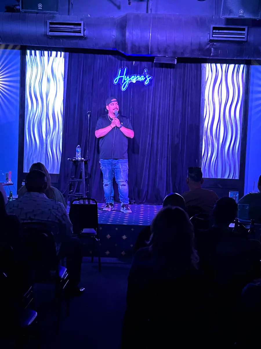 Chris on stage at Hyena's under blue lights